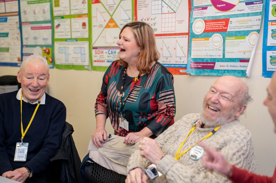 Welsh for adults tutor and students in class laughing