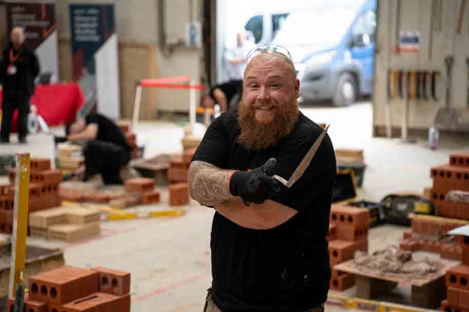 Mature student smiling at camera holding trowel