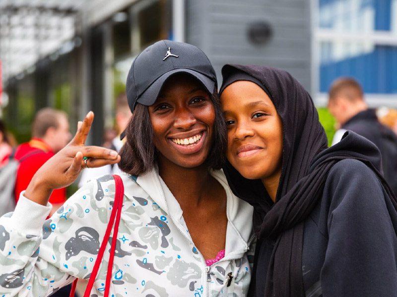 Students smiling outside campus