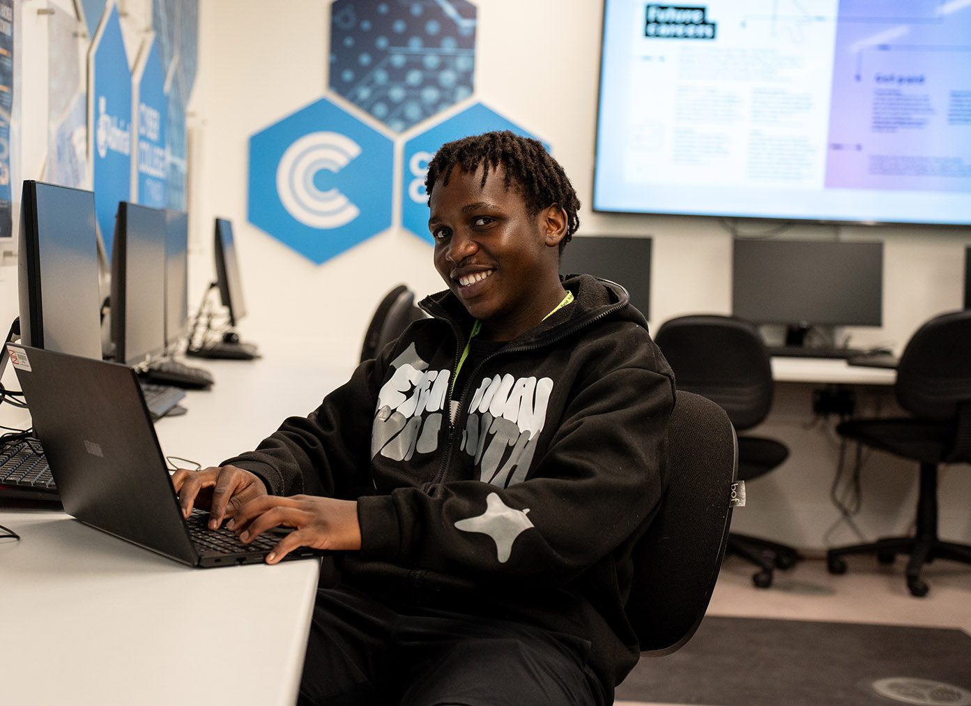 Computing student working on a laptop in the Cyber Hub