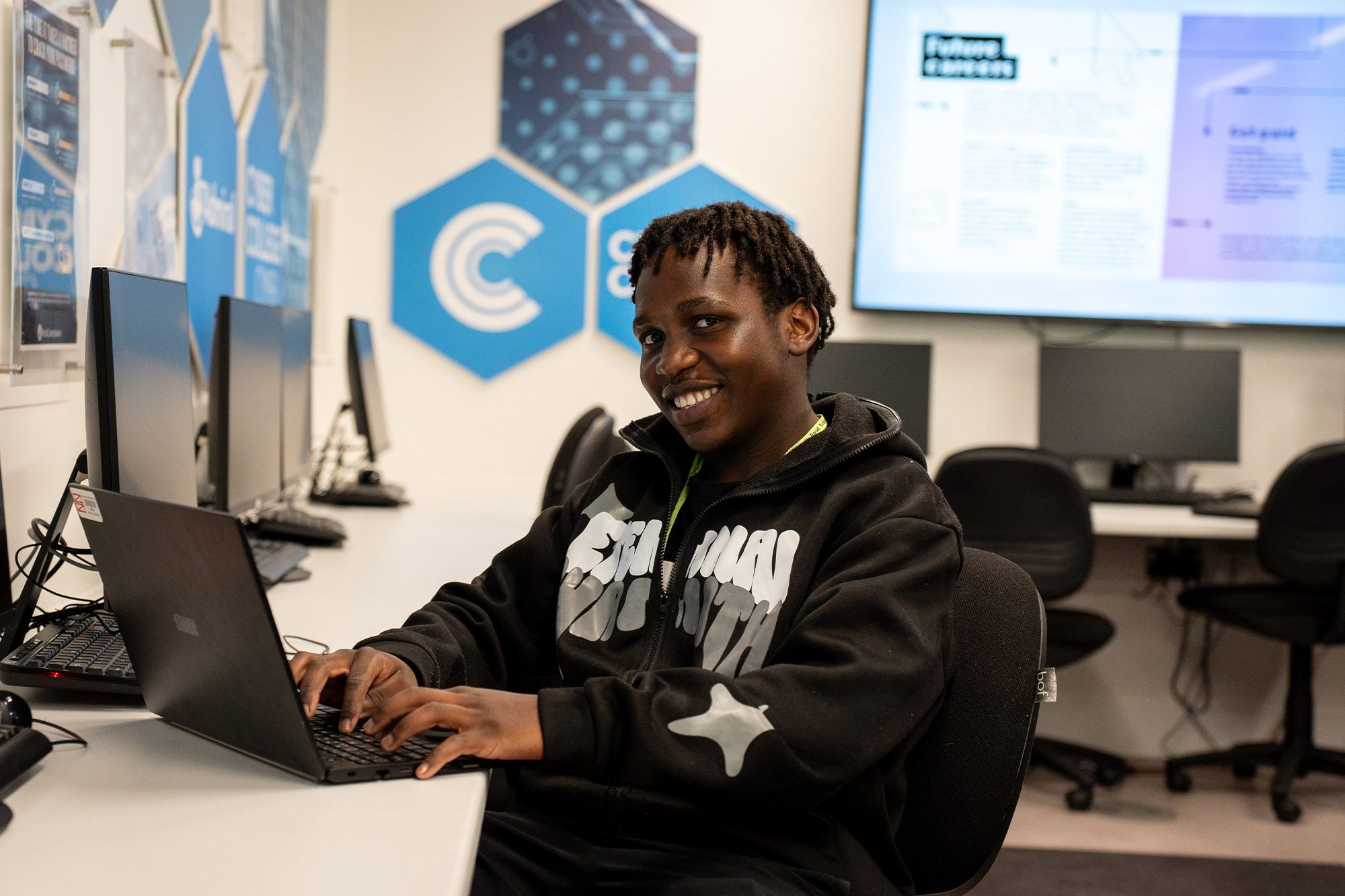 Computing student working on a laptop in the Cyber Hub