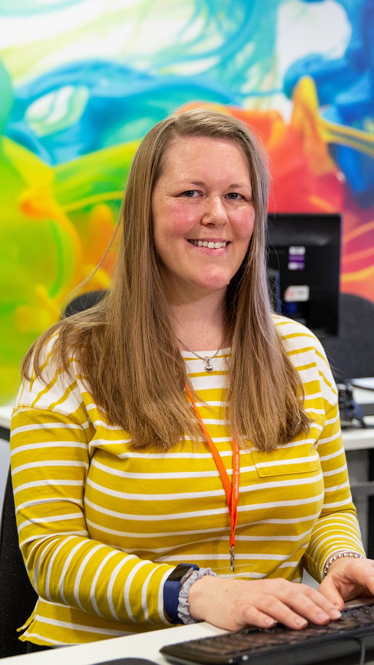 Student in colourful classroom on computer