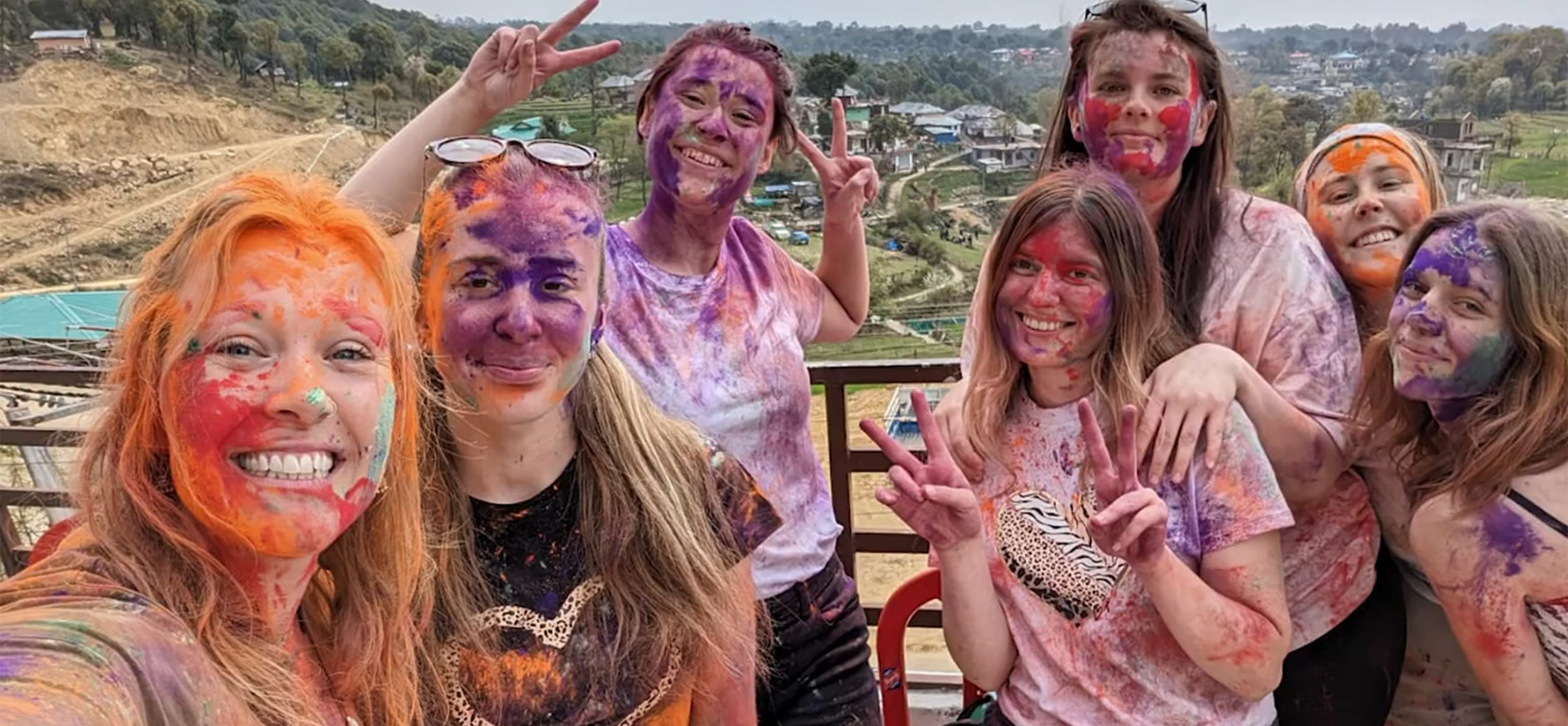 Students posing covered in coloured powder paint
